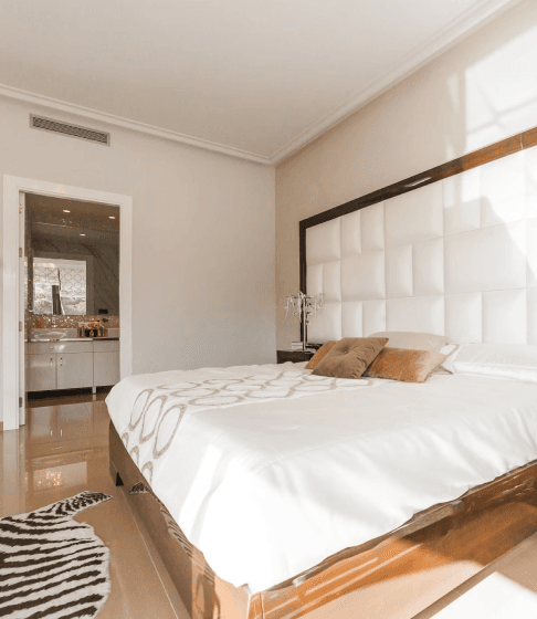 Modern bedroom design with large bed and zebra rug